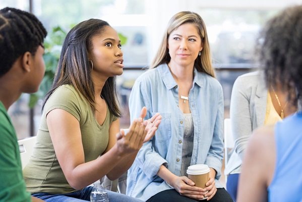 Group of young adults in casual outfits taking part in a small prayer group